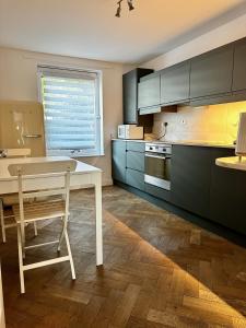 a kitchen with a white table and a white chair at Gero's One Bedroom apartment London NW8 in London