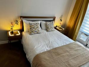 1 dormitorio con 1 cama con almohadas y 2 mesitas de noche en Gero's One Bedroom apartment London NW8, en Londres