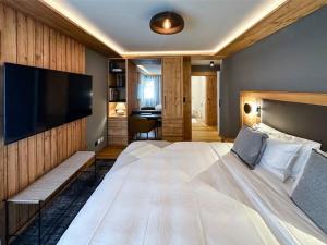 a bedroom with a large bed and a flat screen tv at Chic Alpine Elegance: Designer Retreat in Samedan in Samedan