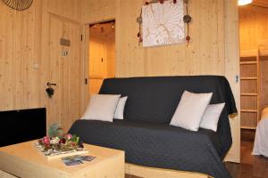 ein Wohnzimmer mit einem Sofa und einem Tisch in der Unterkunft Tiny house - Cabane sur pilotis - Etat Nature in Magnières