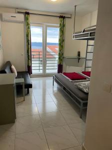 a bedroom with a bed and a balcony with a view at Hostel Dalmatia in Marusici 