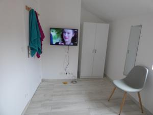 ブリウドにあるDésiréeの壁にテレビと椅子が備わる客室です。