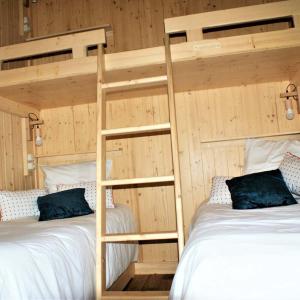 two beds in a room with two bunk beds at Tiny house - Cabane sur pilotis - Etat Nature in Magnières