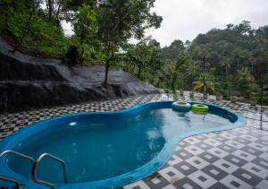 ein Schwimmbad in der Mitte eines Resorts in der Unterkunft Wild Poetry in Munnar