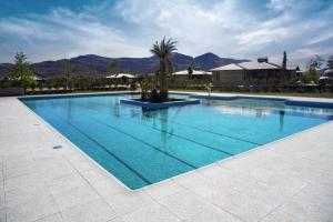 ein großer blauer Pool mit Bergen im Hintergrund in der Unterkunft Los Alerces Resort, Hotel & Spa in San Andres de las Sierras