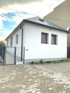 una casa blanca con una puerta delante de ella en Ubytovanie Vo dvore en Badín