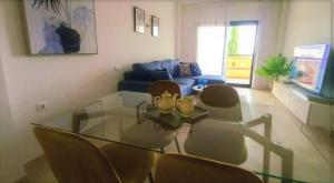 ein Wohnzimmer mit einem Glastisch und Stühlen in der Unterkunft Casa Martinica 12-1-A , Hacienda del Alamo in Murcia