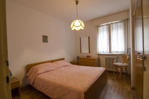 a bedroom with a bed and a chandelier at Accogliente appartamento in Corso Italia in Cortina dʼAmpezzo