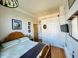 um quarto com uma cama e uma televisão de ecrã plano em Fitz House em Keswick