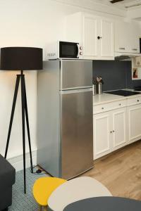 cocina con nevera de acero inoxidable y microondas en Duplex cosy, en Samois-sur-Seine
