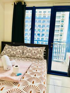 a bed in a room with a large window at Sea Residences Tower F Angel in Manila