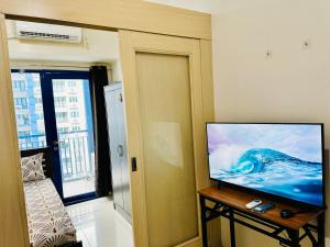 a living room with a flat screen tv on a table at Sea Residences Tower F Angel in Manila