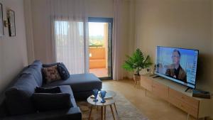 a living room with a couch and a flat screen tv at Casa Martinica 12-1-A , Hacienda del Alamo in Murcia