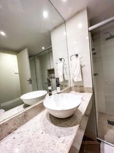 a bathroom with two sinks and a large mirror at Apart Hotel em Brasília - MA Empreendimentos in Brasilia