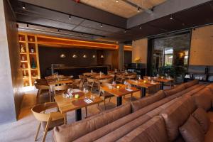 a restaurant with tables and couches and a couch at Hualta Hotel Mendoza, Curio Collection by Hilton in Mendoza