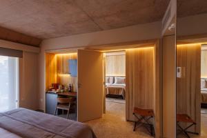 een hotelkamer met een bed, een bureau en een slaapkamer bij Hualta Hotel Mendoza, Curio Collection by Hilton in Mendoza
