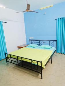 Ce lit se trouve dans un dortoir doté d'un mur bleu. dans l'établissement Bamboo garden, à Varkala