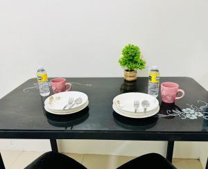 una mesa negra con platos, tenedores y agua en Sea Residences - Property Val Alano 0995-448-8872 en Manila