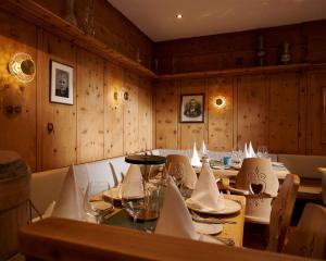 d'une salle à manger avec une table, des chaises et des murs en bois. dans l'établissement Hotel Flüela Davos, in The Unbound Collection by Hyatt, à Davos