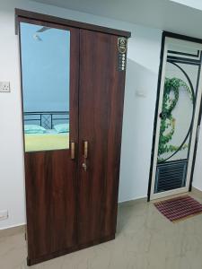 - une porte en bois dans une chambre avec fenêtre dans l'établissement Bamboo garden, à Varkala