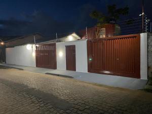 une clôture avec des portes en bois dans une rue la nuit dans l'établissement Container LB com garagem para carros de até 4,5M, à Boa Vista