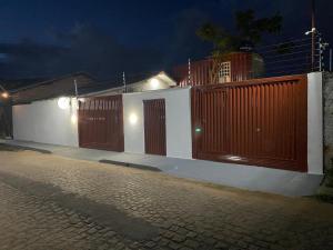 a fence with wooden doors on a street at night at Container LB com garagem para carros de até 4,5M in Boa Vista