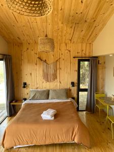 a bedroom with a bed and a wooden wall at Finca Granero in Potrero de Garay