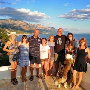 uma família posando para uma foto numa varanda em Hostel Dalmatia em Marusici 