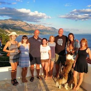 a family posing for a picture on a balcony at Hostel Dalmatia in Marusici 