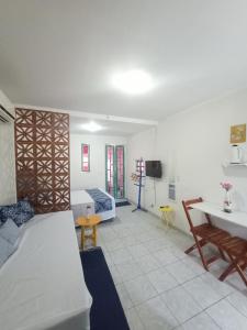 a room with two beds and a table and a couch at Chalés Caiçara Serrambi in Porto De Galinhas
