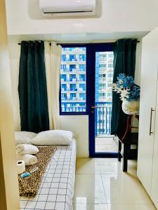 um pequeno quarto com uma cama e uma janela em Sea Residences - Call Ang Alano em Manila