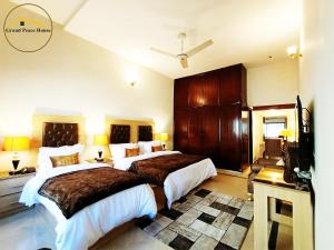 a hotel room with two beds and a television at Grand Peace House I in Islamabad