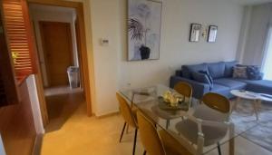 ein Wohnzimmer mit einem Glastisch und einem blauen Sofa in der Unterkunft Casa Martinica 12-1-A , Hacienda del Alamo in Murcia