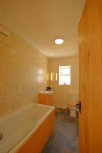 a bathroom with a tub and a toilet at Gadlys Cottage Sea Views Dog Friendly in Holyhead