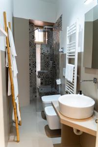 y baño con lavabo, aseo y ducha. en Residence Le Vie del Centro, en Matera