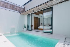 a swimming pool in a house with a bedroom at Babali 希腊风格别墅 in Canggu