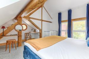 a bedroom with a large bed with blue curtains at La Rivière 10 mn DisneylandParis in Chalifert