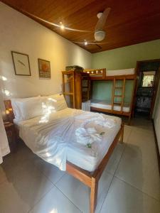 um quarto com uma cama com lençóis brancos em Pousada Albatroz em Abraão