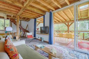 a living room with a couch and a tv at La Rivière 10 mn DisneylandParis in Chalifert