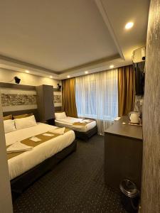 a hotel room with two beds and a desk at Moonlight Suit Hotel Taksim in Istanbul