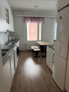 an empty kitchen with a table and a refrigerator at Apartment Korsholma2 in Vaasa
