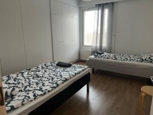 Cette chambre comprend 2 lits et une fenêtre. dans l'établissement Apartment Korsholma2, à Vaasa