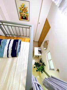 a small attic bedroom with a bed and a mirror at Lucky Hotel Apartment in Ho Chi Minh City