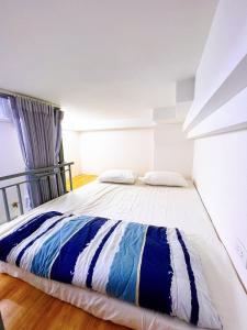 a bedroom with a large bed with blue and white sheets at Lucky Hotel Apartment in Ho Chi Minh City