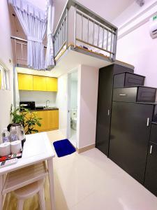 a kitchen with a black refrigerator and a staircase at Lucky Hotel Apartment in Ho Chi Minh City