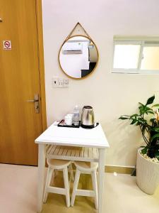 a small white table with a mirror on the wall at Lucky Hotel Apartment in Ho Chi Minh City