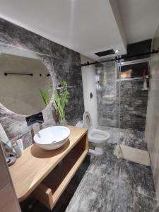 a bathroom with a sink and a toilet and a mirror at Apartamento, tranquilidad y paz in Apartadó