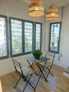 a table and chairs in a room with windows at Hostal Zaragoza Centro in Zaragoza