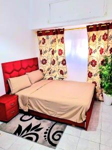 1 cama con cabecero rojo en una habitación en Mi mini estudio 2, en Rabat