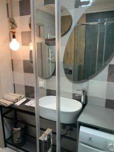 uma casa de banho com um lavatório e um espelho em Riverside apartment self check-in em Klaipėda